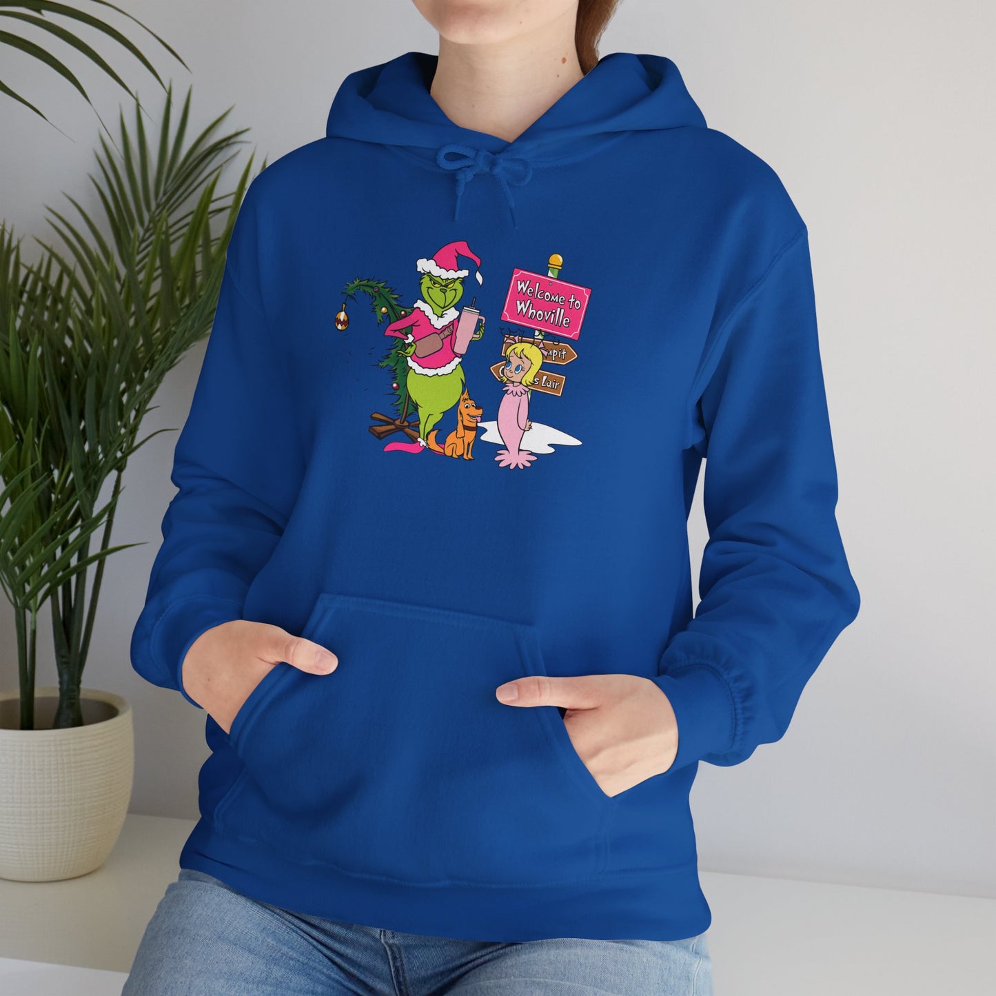 Welcome to Merryville Christmas Hoodie – Cute Green Creature & Winter Village Sweatshirt (Unisex)