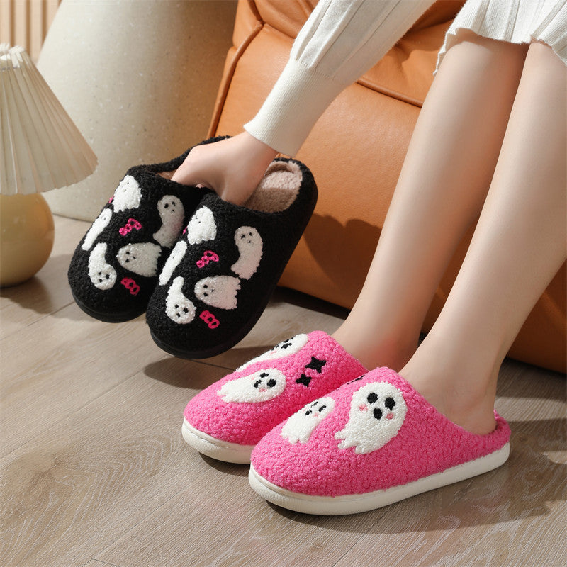 Black and pink cartoon slippers worn by a person on a wooden floor.