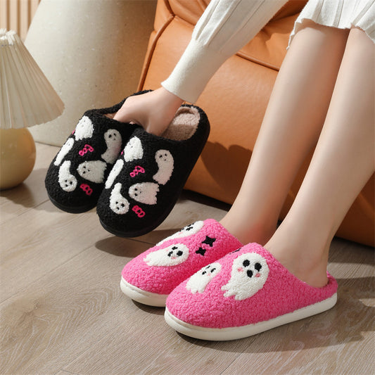 Black and pink cartoon slippers worn by a person on a wooden floor.
